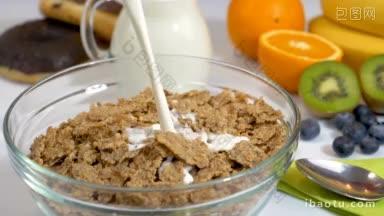把牛奶倒在麦片片上做健康有机早餐的慢动作镜头